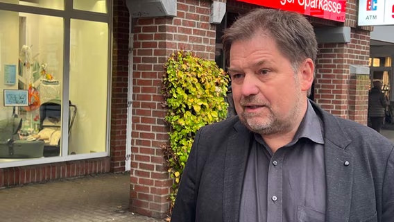 Haspa-Anwalt Thomas Schikorra gibt ein Interview vor einer Sparkassenfiliale